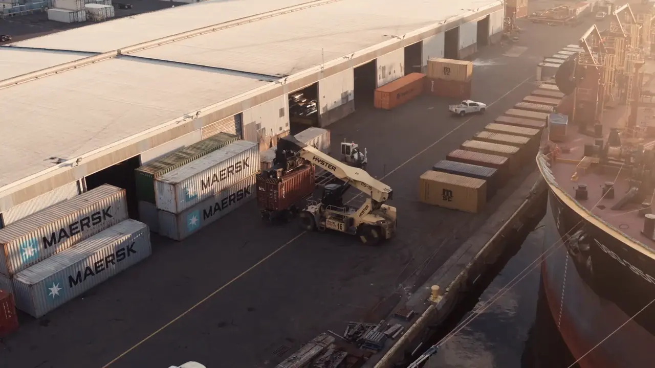 Containers being handled at a marine terminal. Generic industrial imagery, not an Alyaan facility.